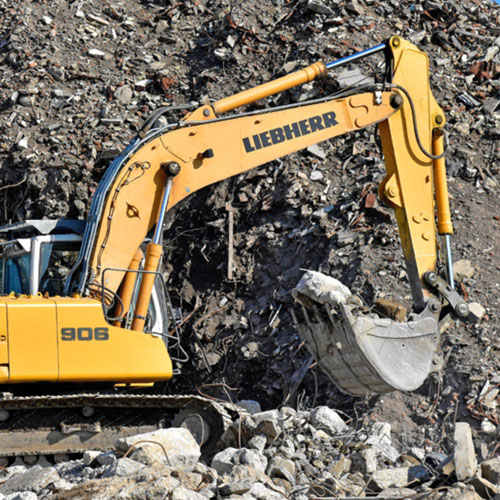 Yellow Liebherr digger excavating rubble